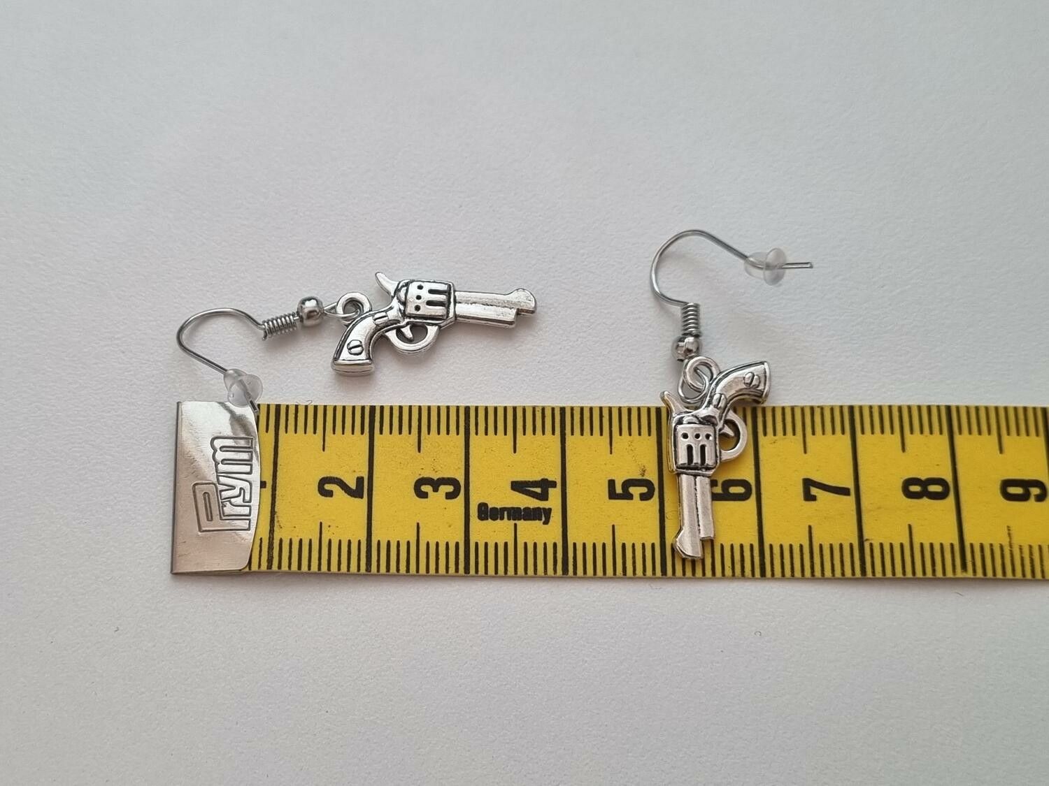 Ett par örhängen, Pistoler, pistolberlocker (silverfärgade)