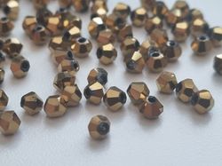 100 st guldfärgade bicone pärlor (4 mm)