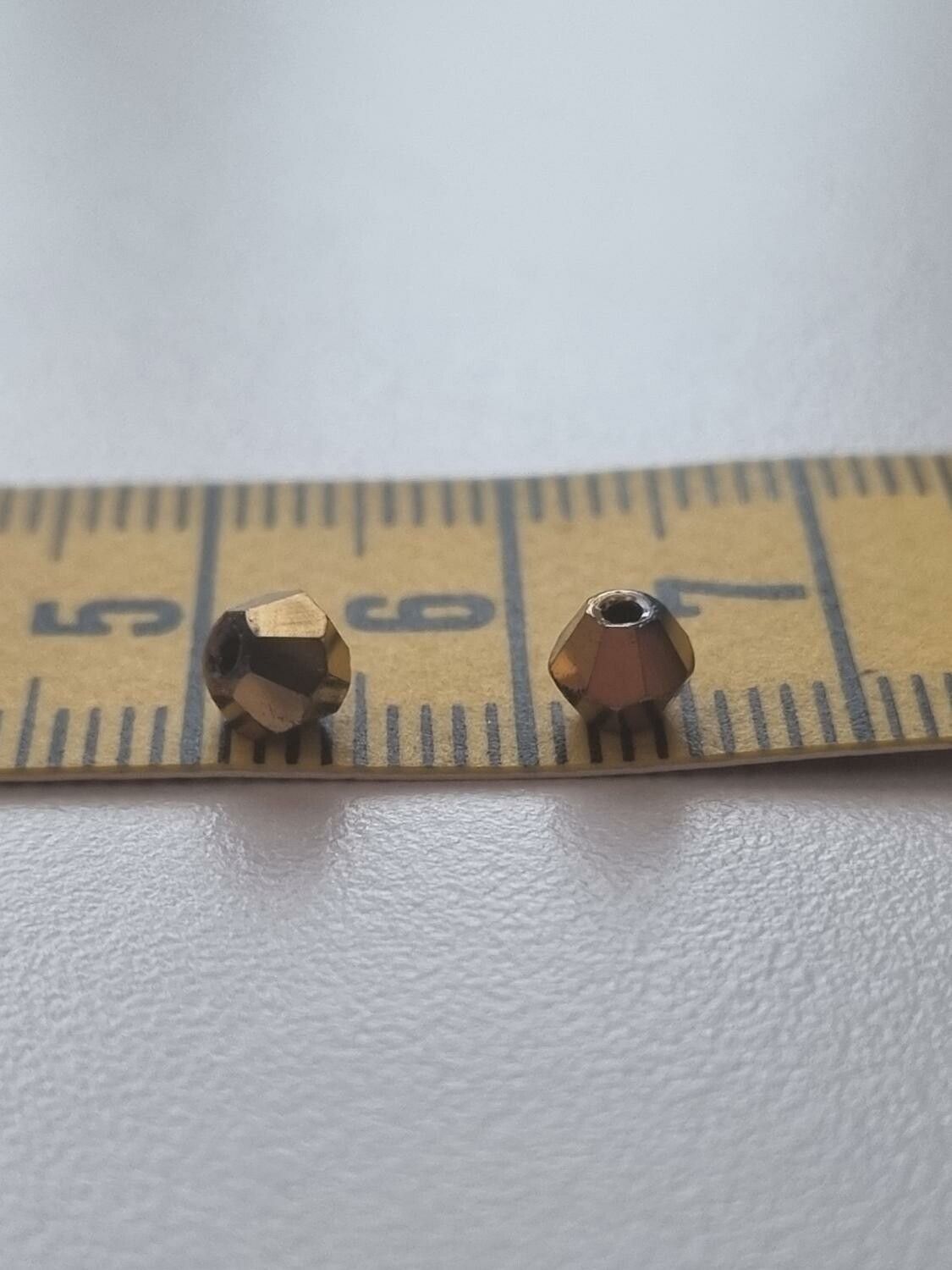100 st guldfärgade bicone pärlor (4 mm)