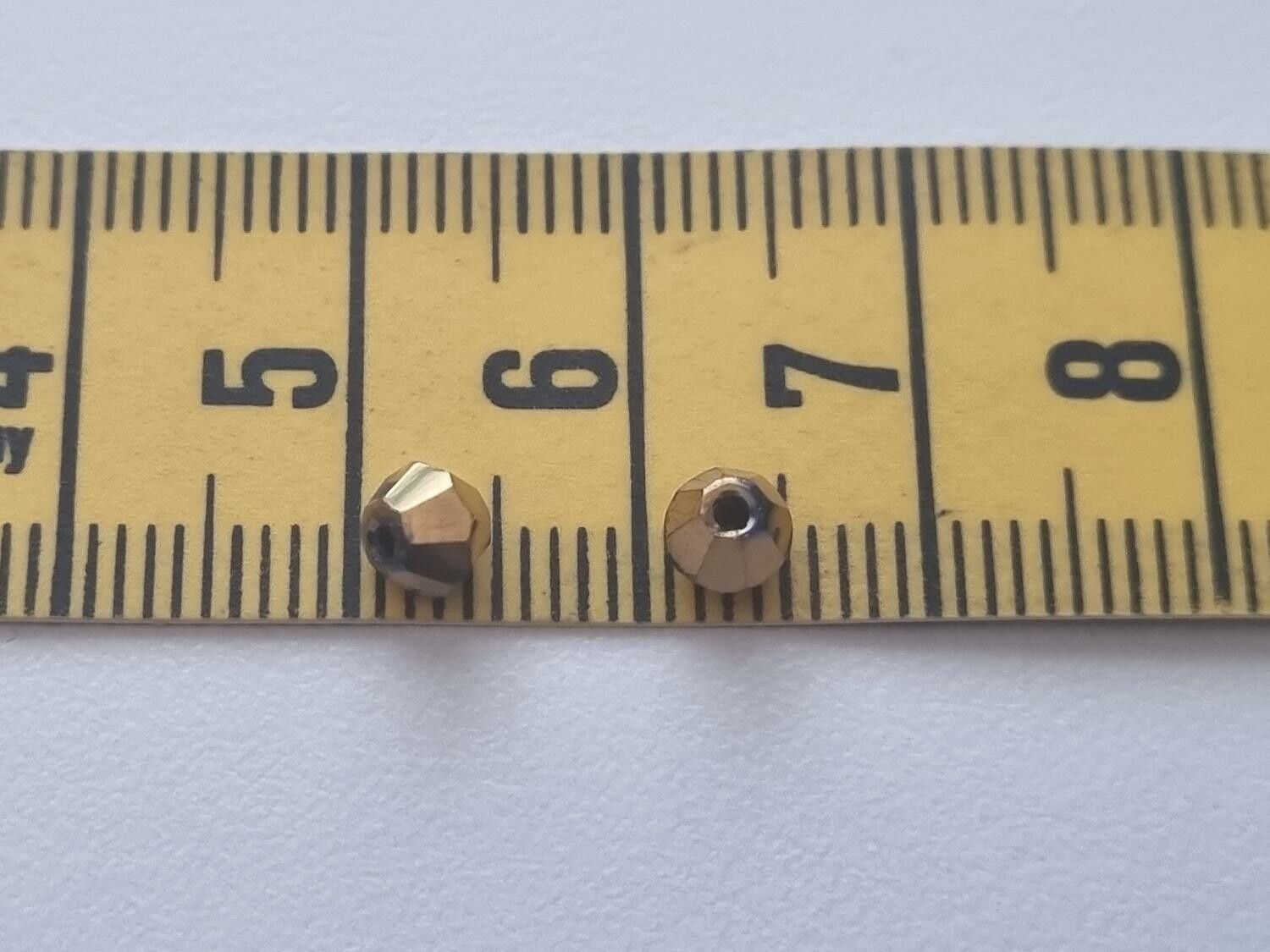 100 st guldfärgade bicone pärlor (4 mm)