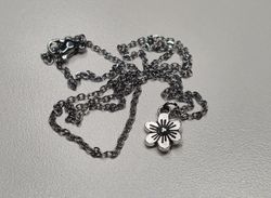 Halsband med en silverfärgad liten blomma / charm