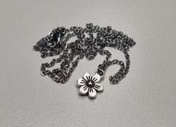 Halsband med en silverfärgad liten blomma / charm