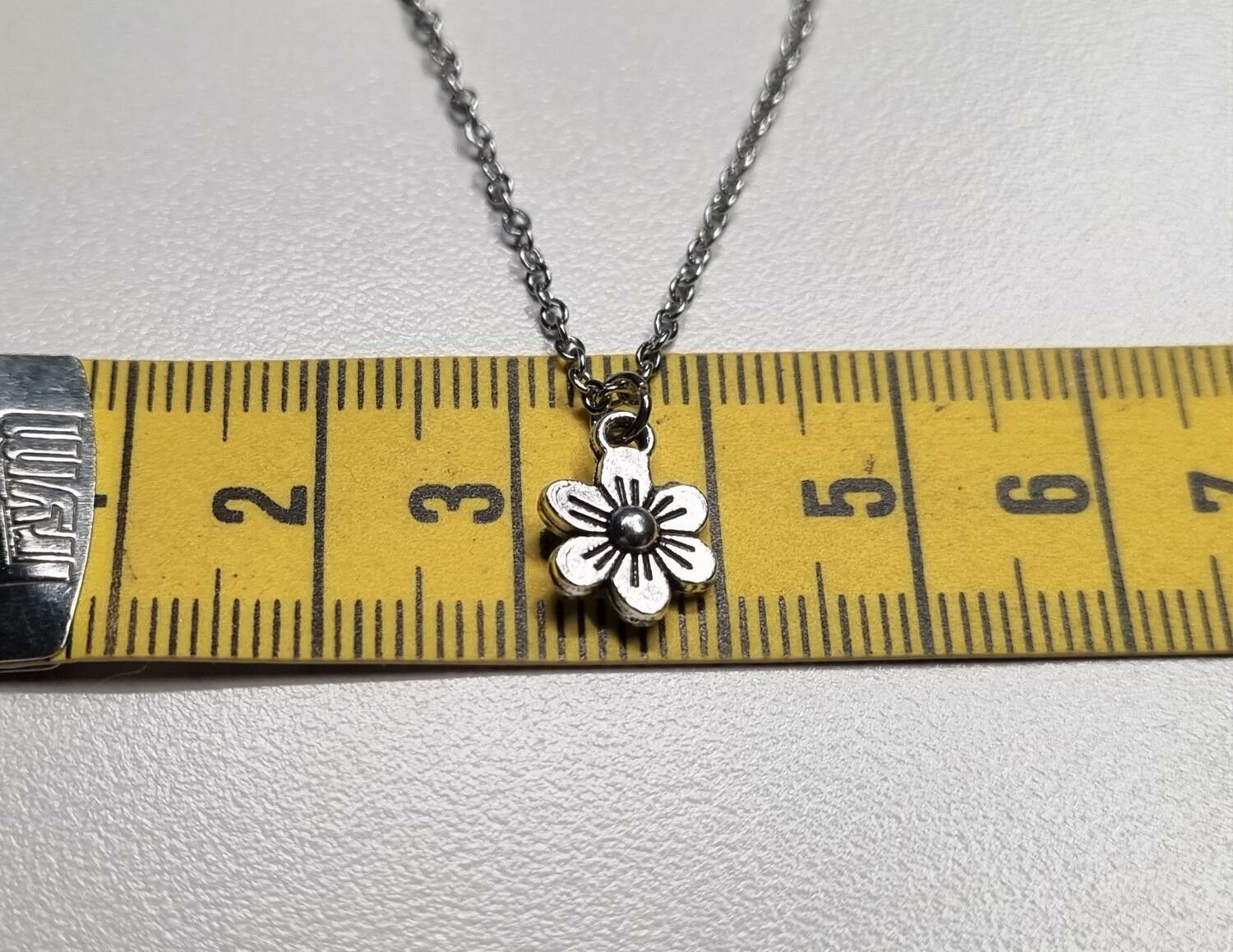 Halsband med en silverfärgad liten blomma / charm