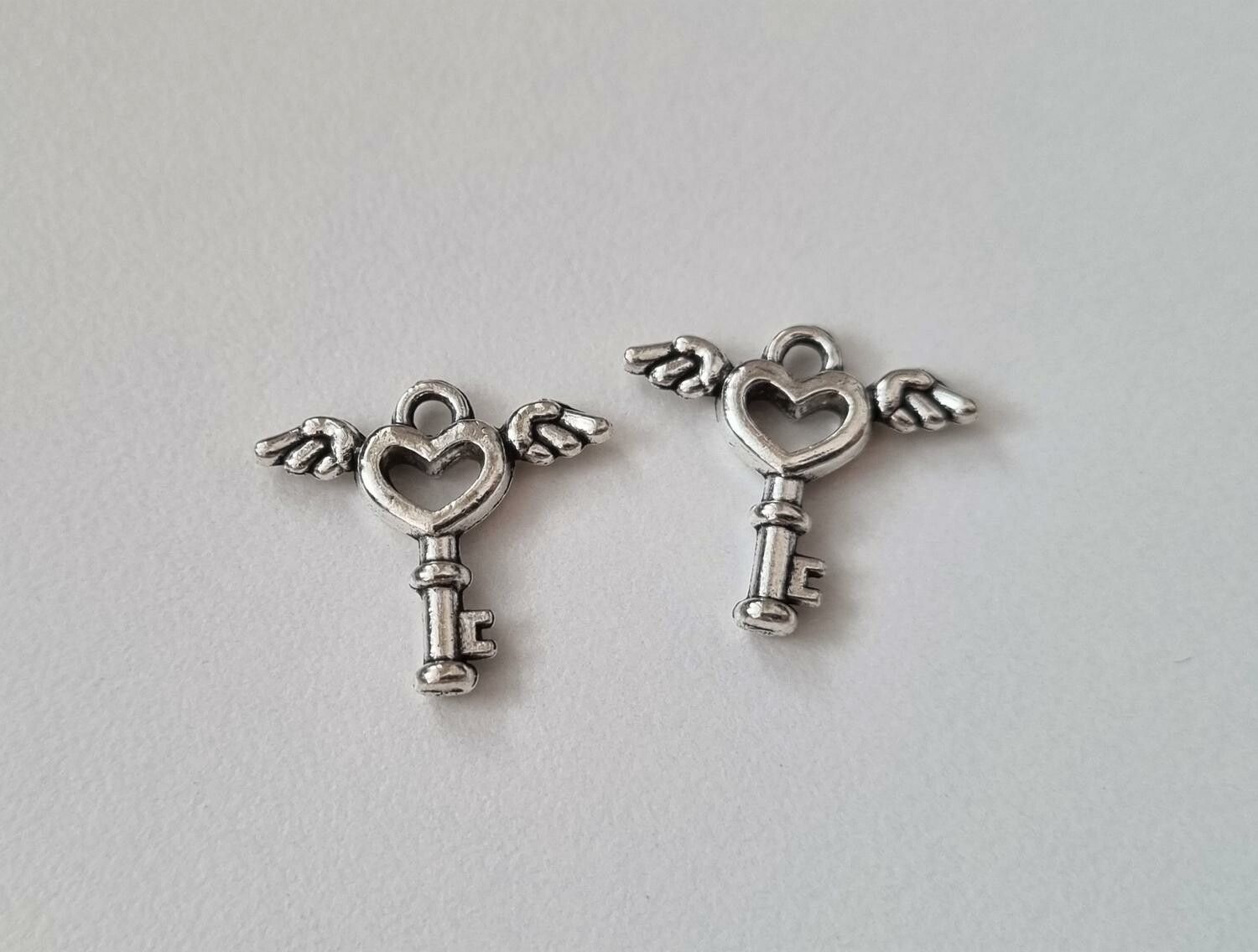 2 st silverfärgade nycklar med vingar. Berlocker / charms
