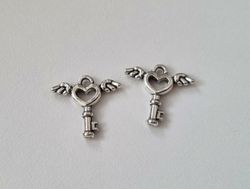 2 st silverfärgade nycklar med vingar. Berlocker / charms