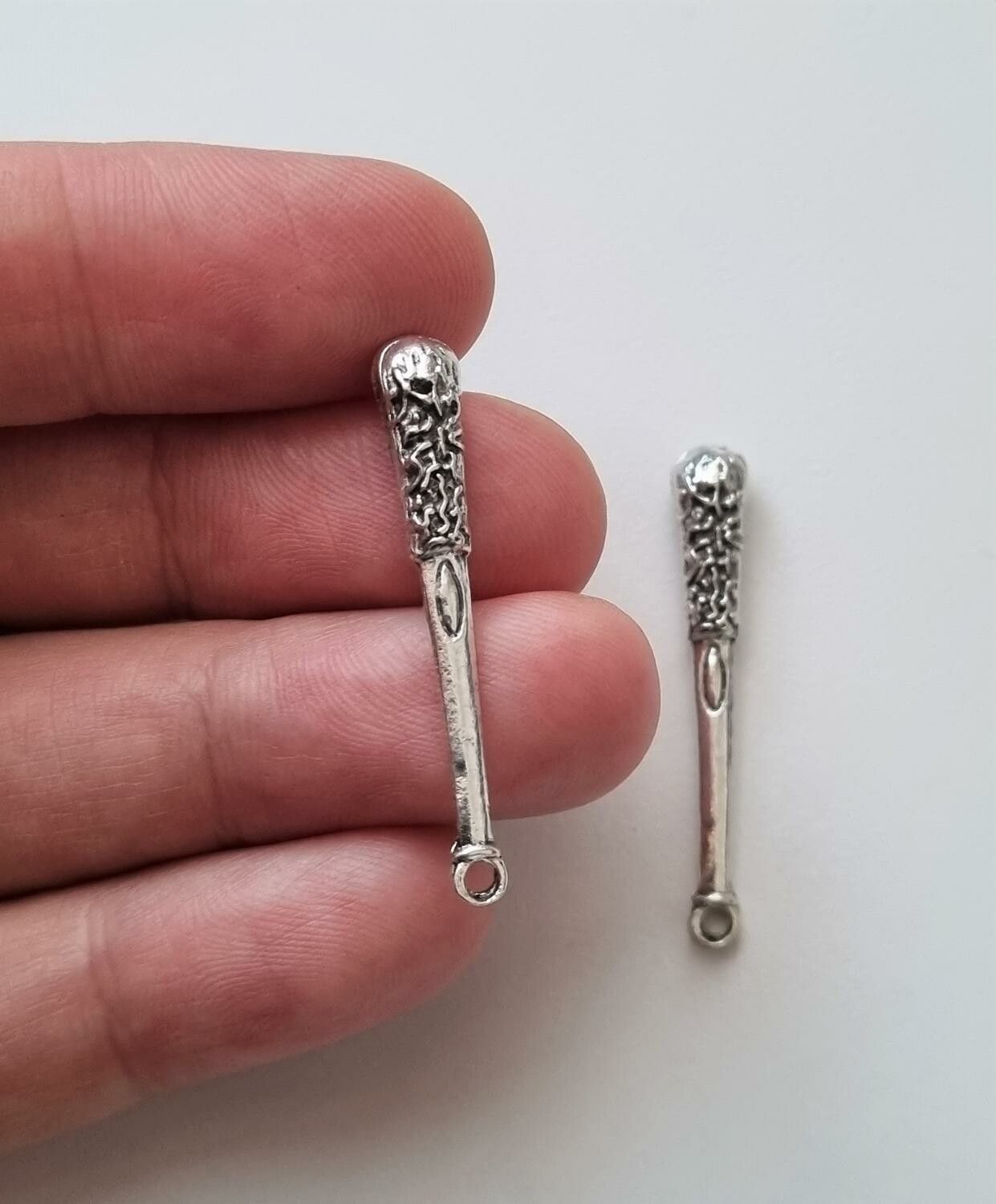 2 st silverfärgade klubbor,. Berlocker / charms