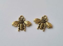 2 st guldfärgade bin,. Berlocker / charms