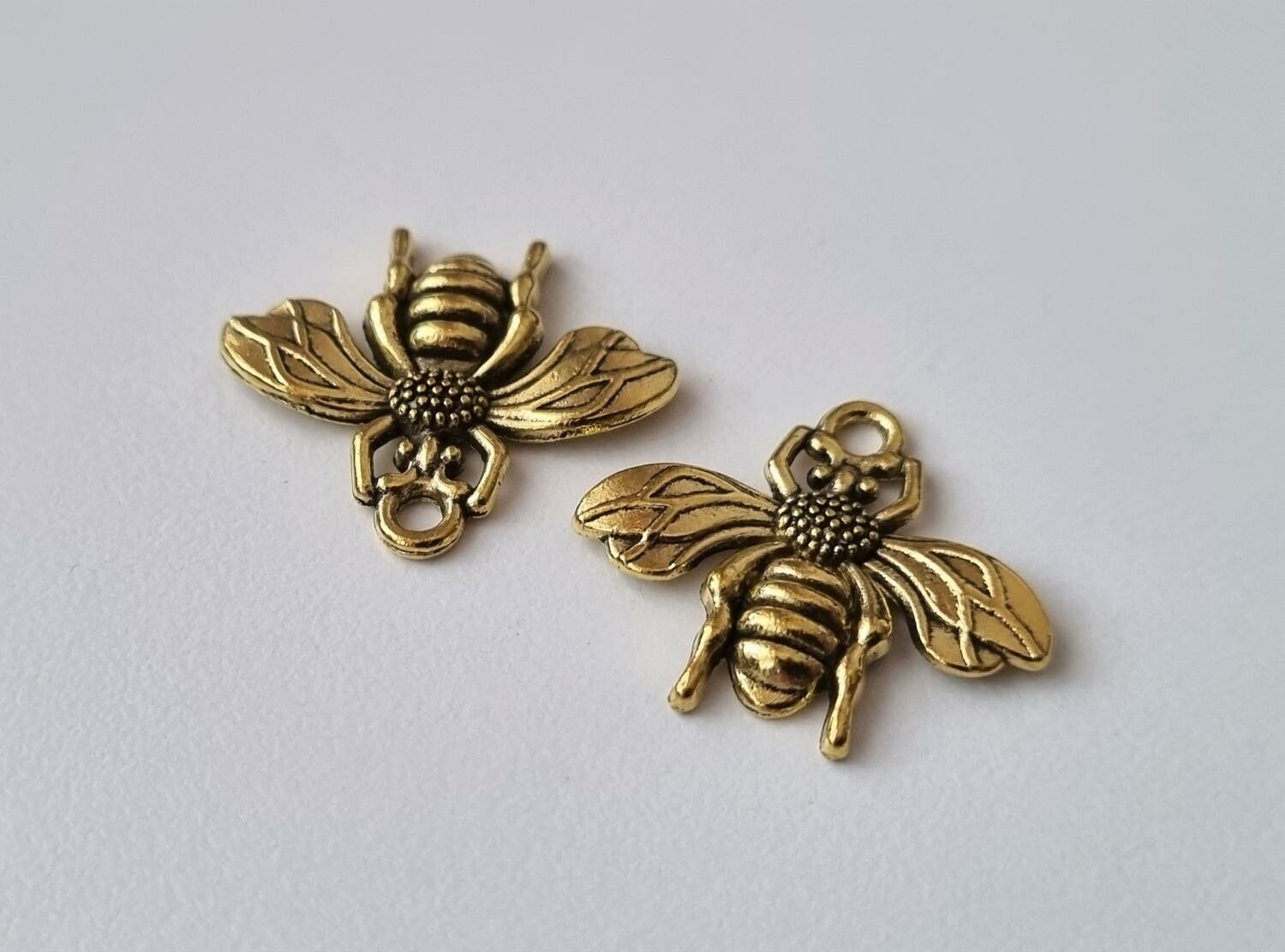 2 st guldfärgade bin,. Berlocker / charms