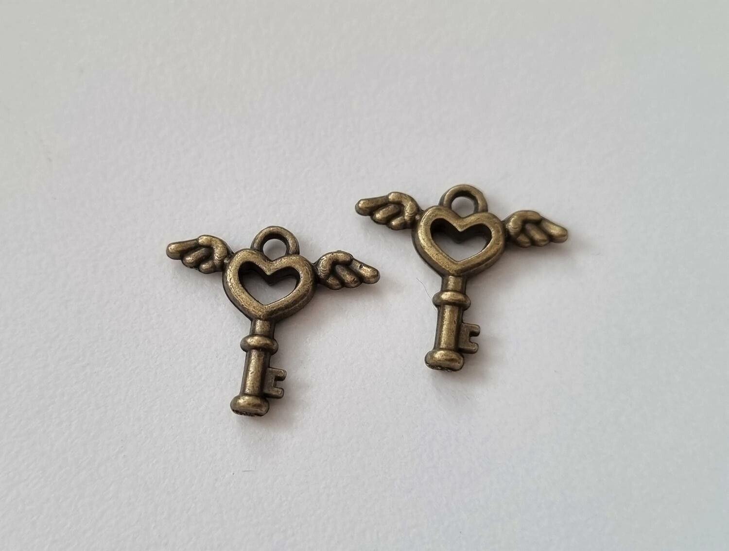 2 st bronsfärgade nycklar med vingar. Berlocker / charms