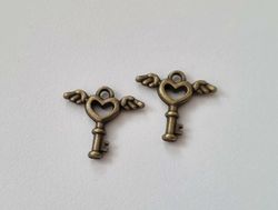 2 st bronsfärgade nycklar med vingar. Berlocker / charms