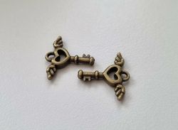2 st bronsfärgade nycklar med vingar. Berlocker / charms