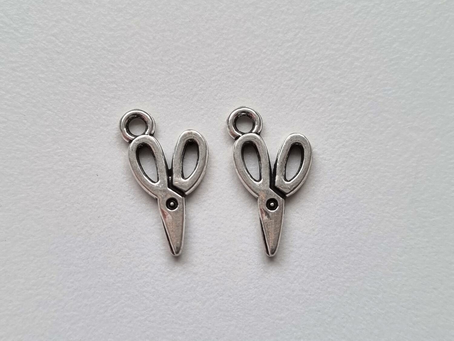 2 st silverfärgade saxar. Berlocker / charms