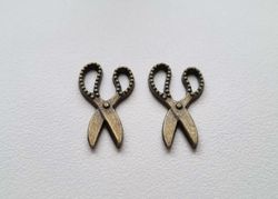 2 st bronsfärgade saxar. Berlocker / charms
