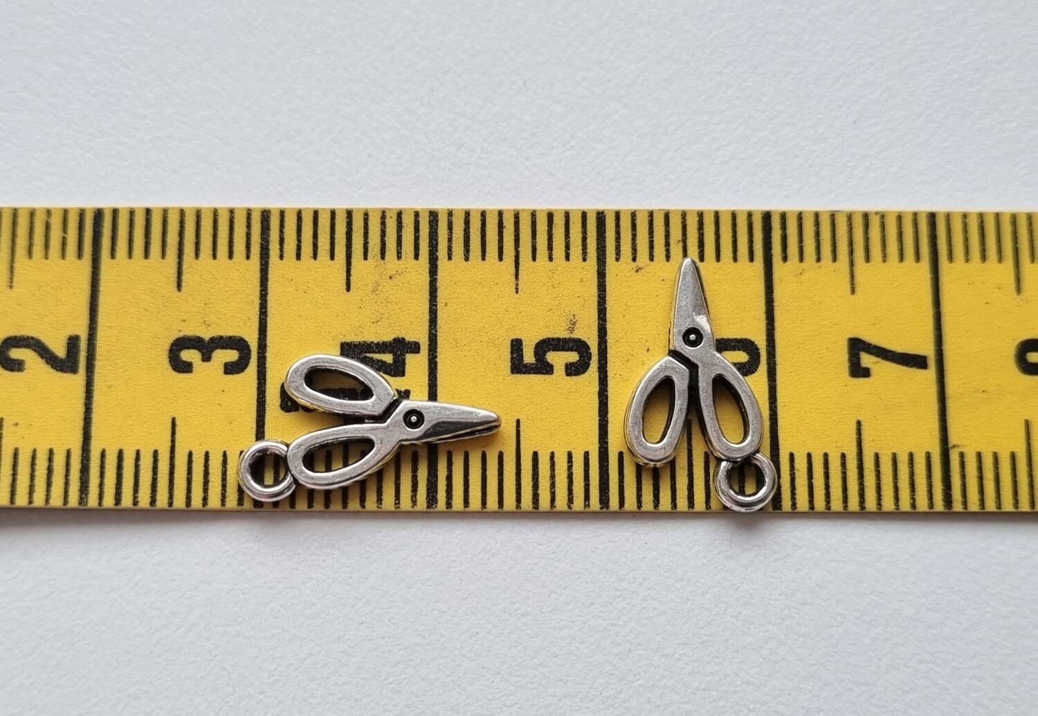 2 st silverfärgade saxar. Berlocker / charms