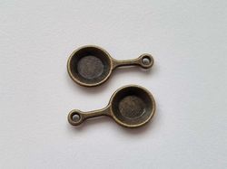 2 st bronsfärgade stekpannor. Berlocker / charms
