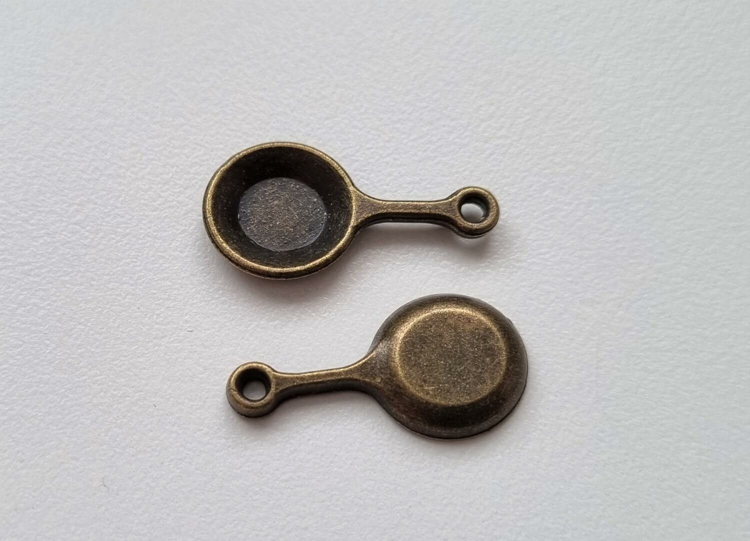 2 st bronsfärgade stekpannor. Berlocker / charms
