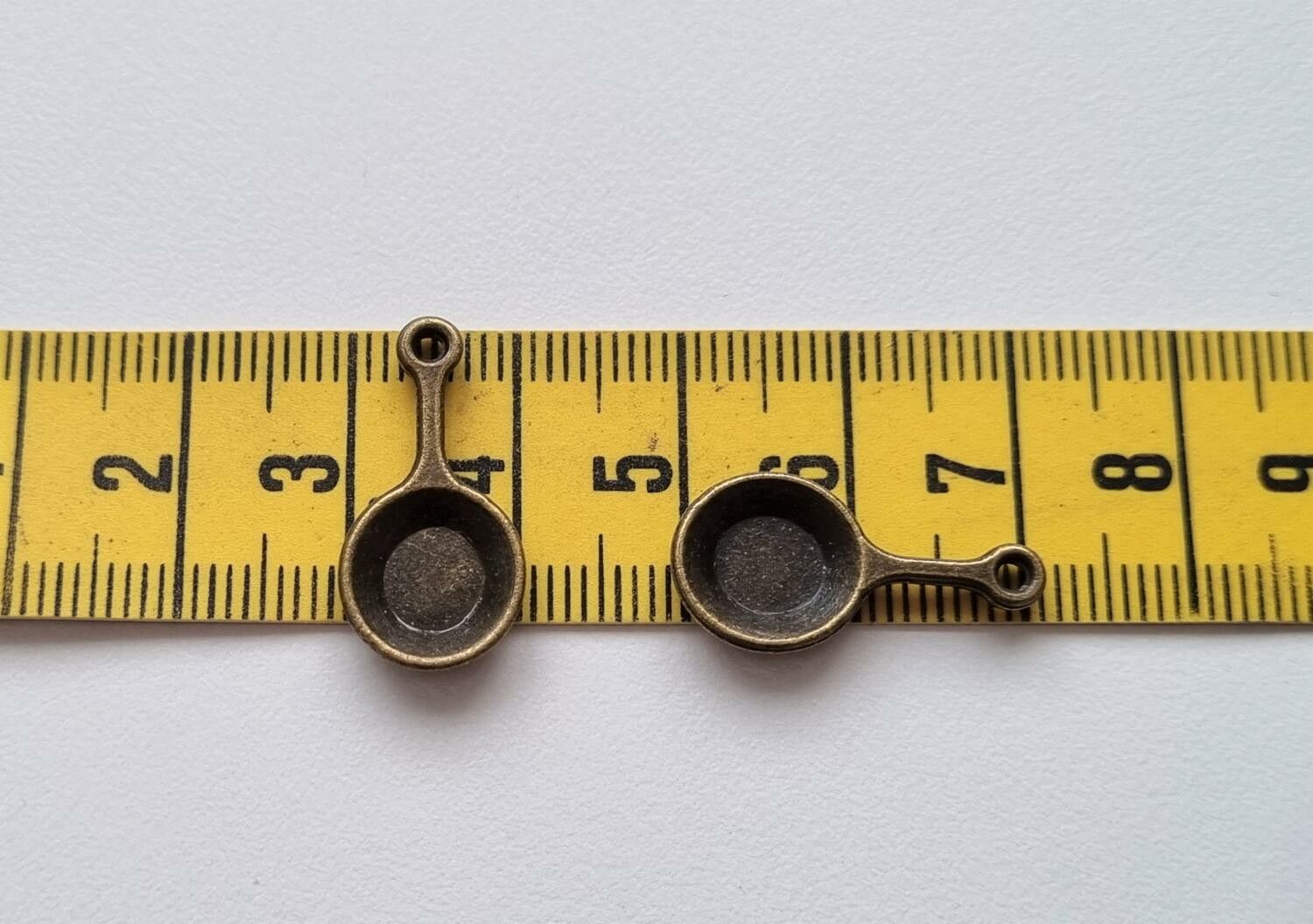 2 st bronsfärgade stekpannor. Berlocker / charms