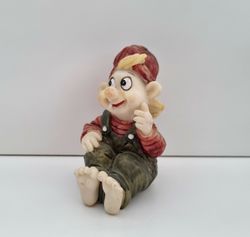 Tomtenisse som sitter på rumpan