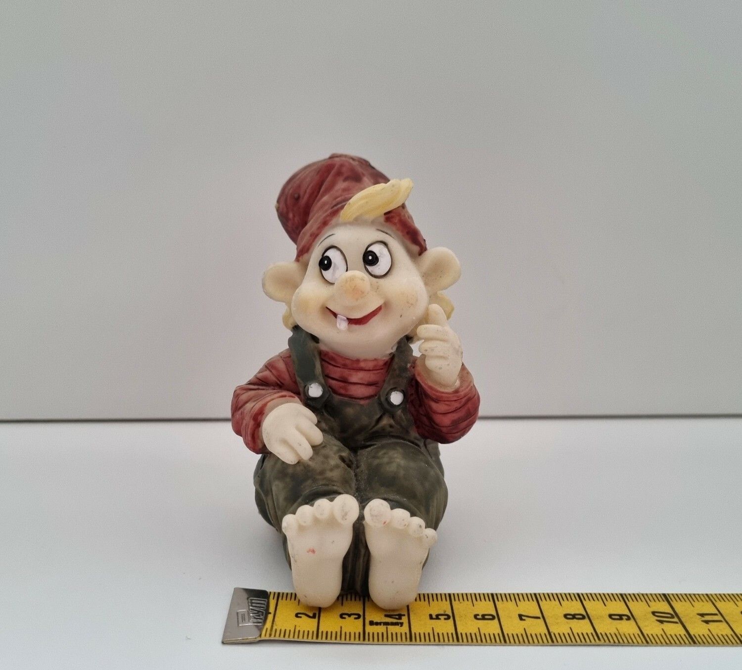 Tomtenisse som sitter på rumpan