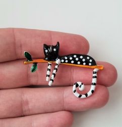 Brosch, vilande katt på gren