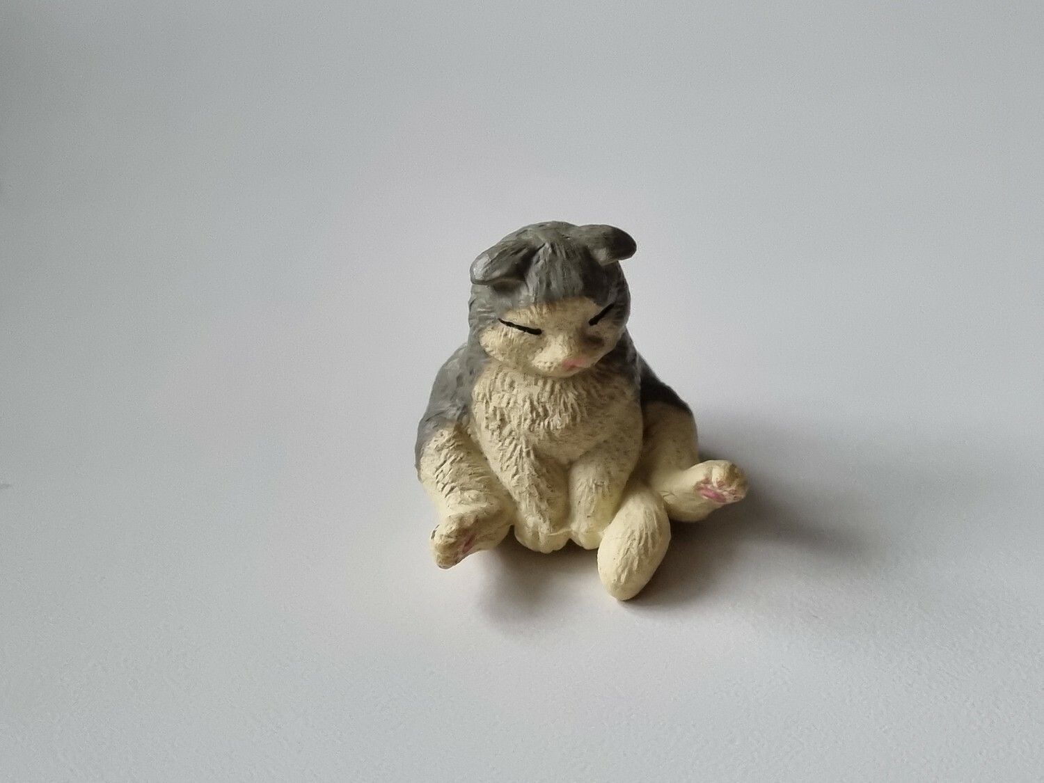 Katt som sitter på baken / miniatyr