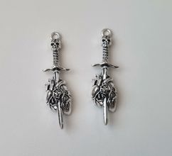2 st silverfärgade dödskallesvärd genom ett hjärta,. Berlocker / charms