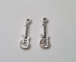 2 st silverfärgade små gitarrer. Berlocker / charms / miniatyrer