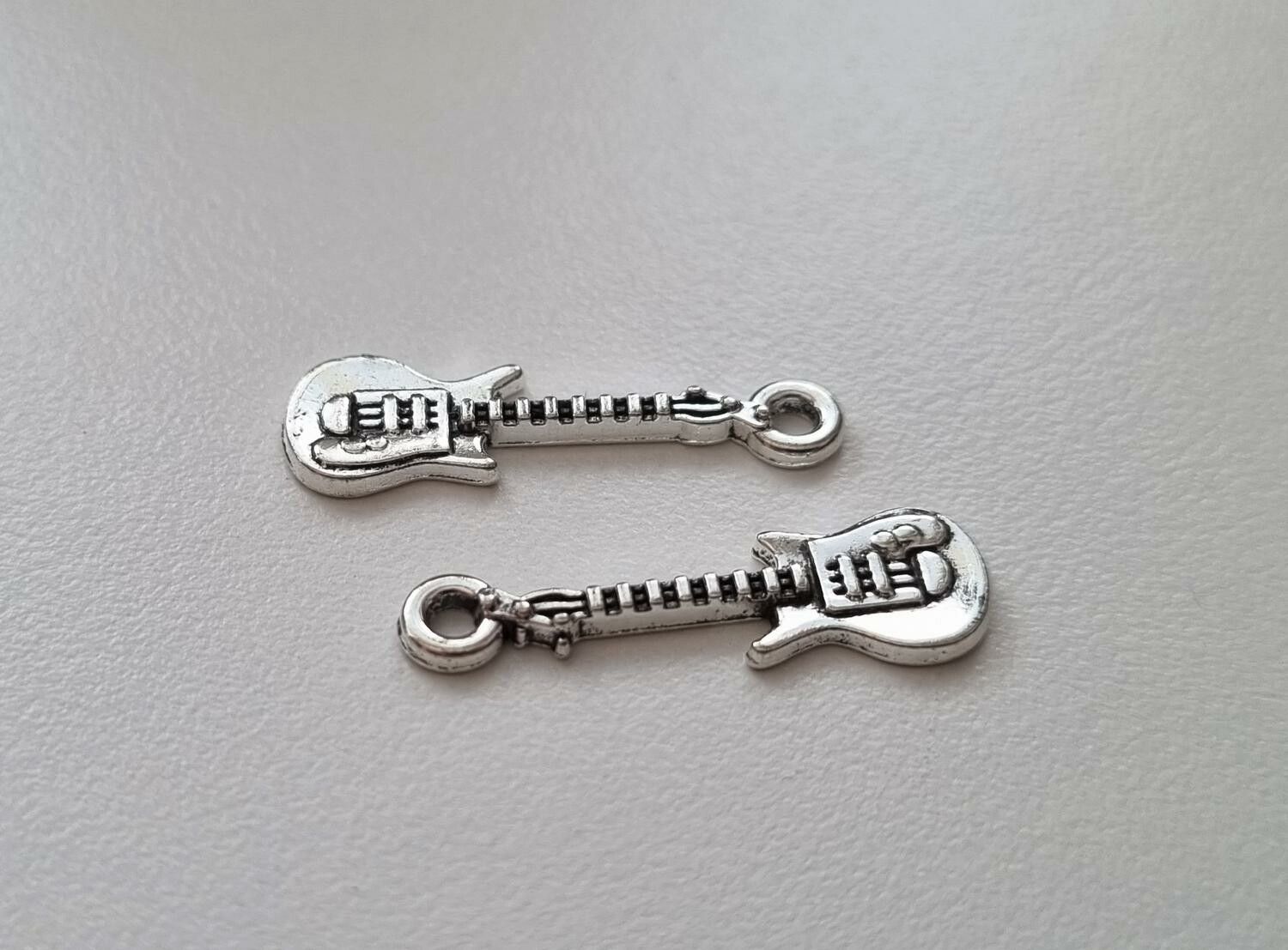 2 st silverfärgade små gitarrer. Berlocker / charms / miniatyrer