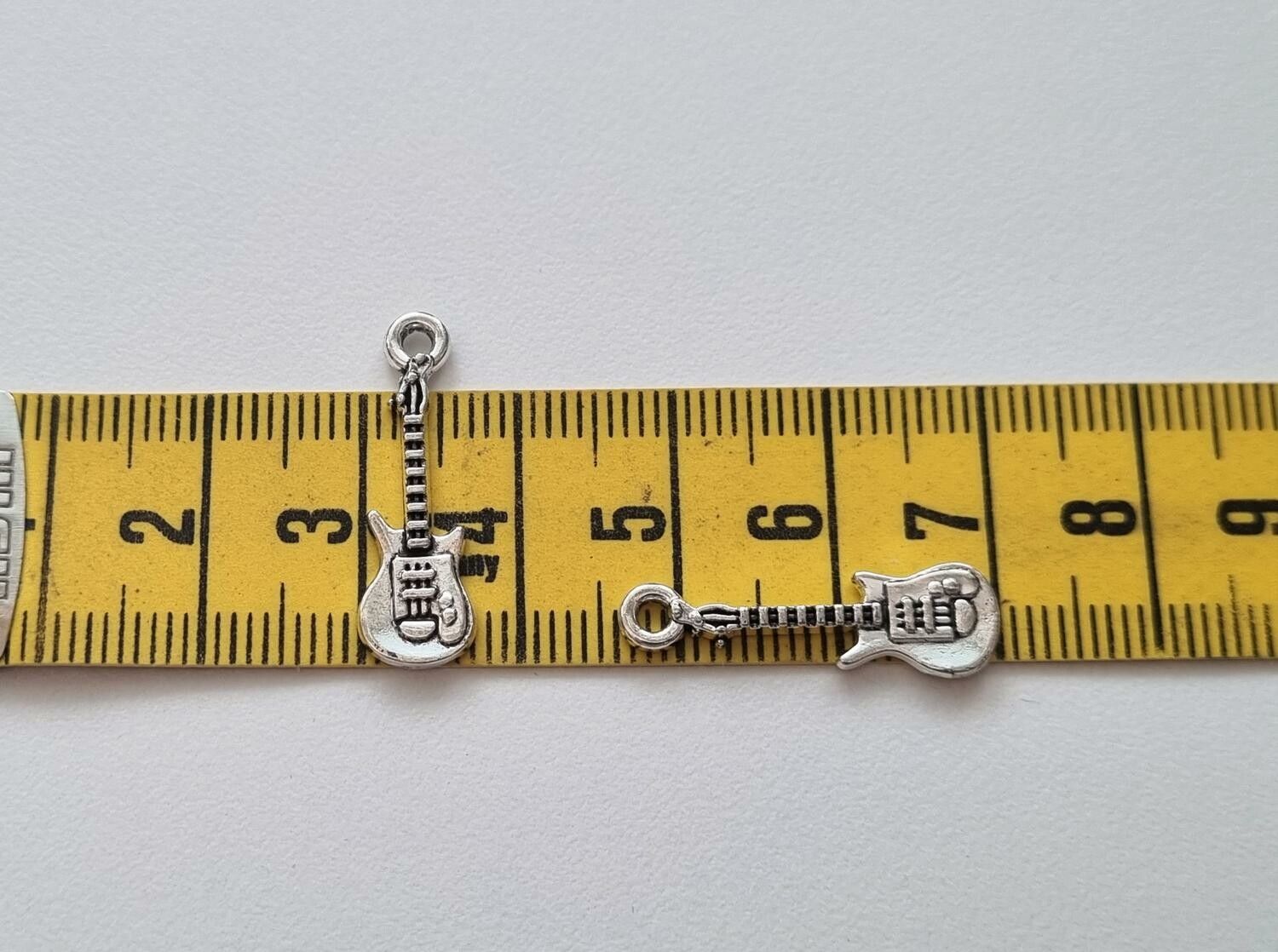 2 st silverfärgade små gitarrer. Berlocker / charms / miniatyrer