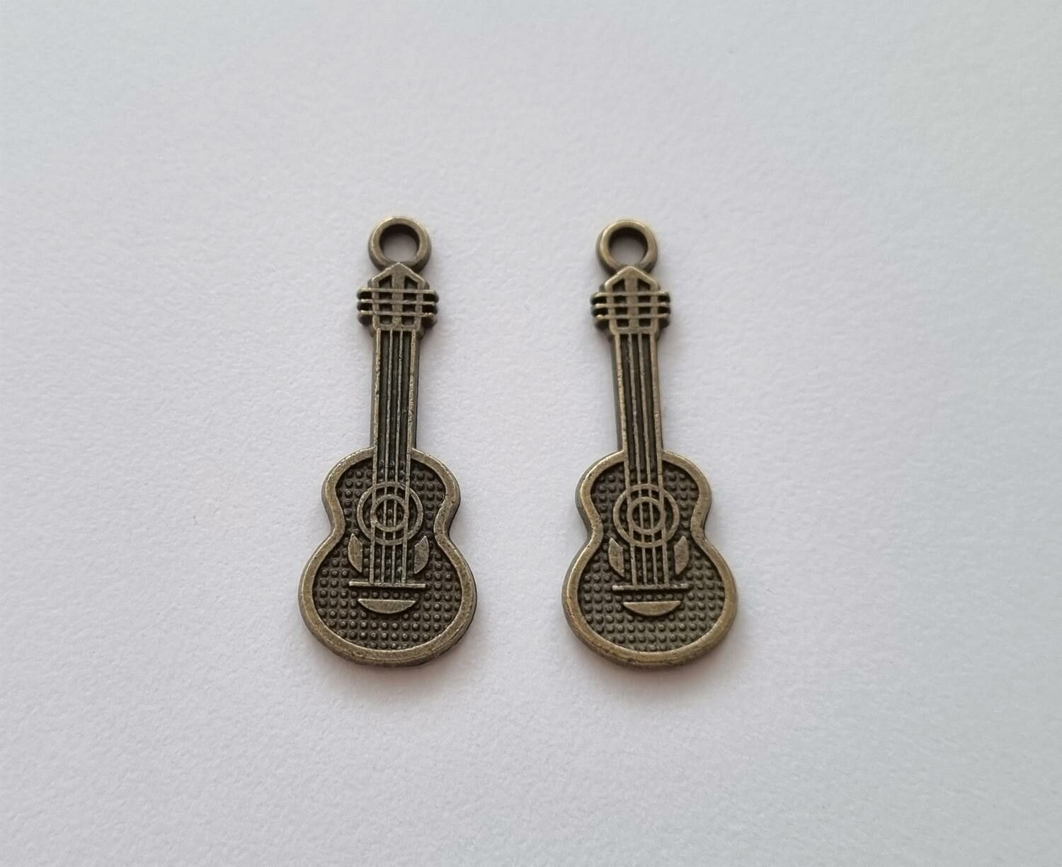 2 st bronsfärgade små gitarrer. Berlocker / charms / miniatyrer