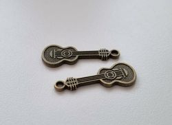 2 st bronsfärgade små gitarrer. Berlocker / charms / miniatyrer