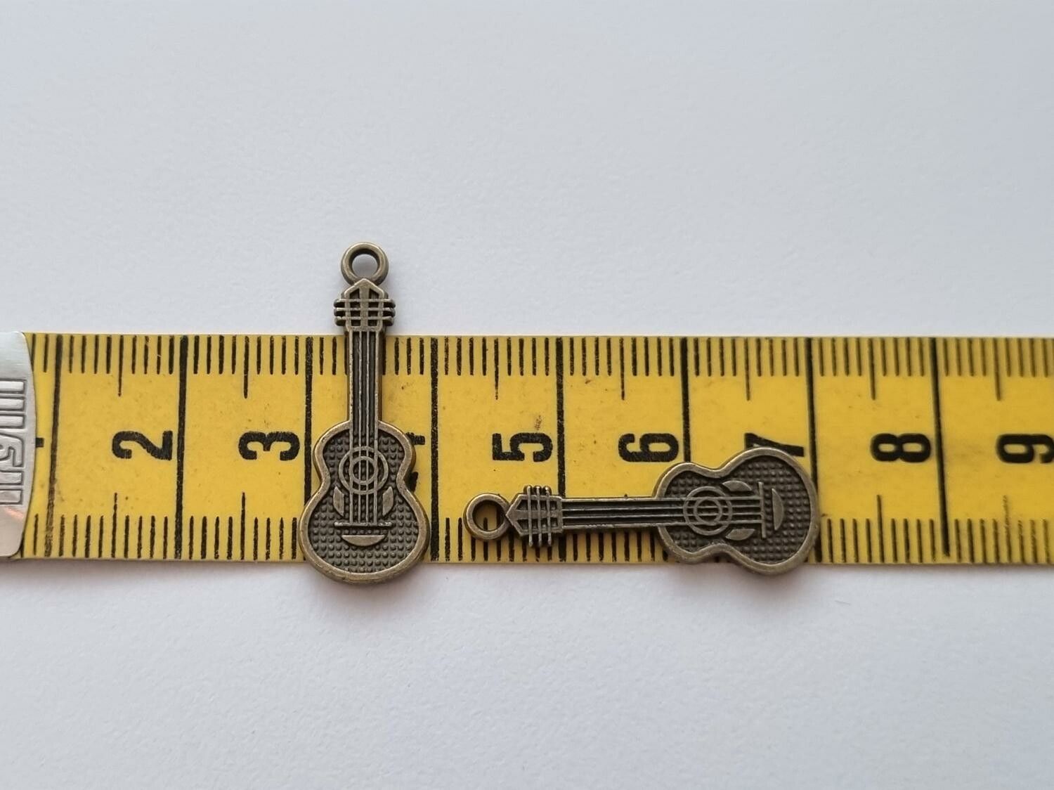 2 st bronsfärgade små gitarrer. Berlocker / charms / miniatyrer