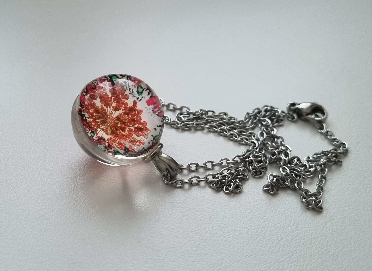 Halsband (50 cm) med fin rund orange/röd berlock i glas