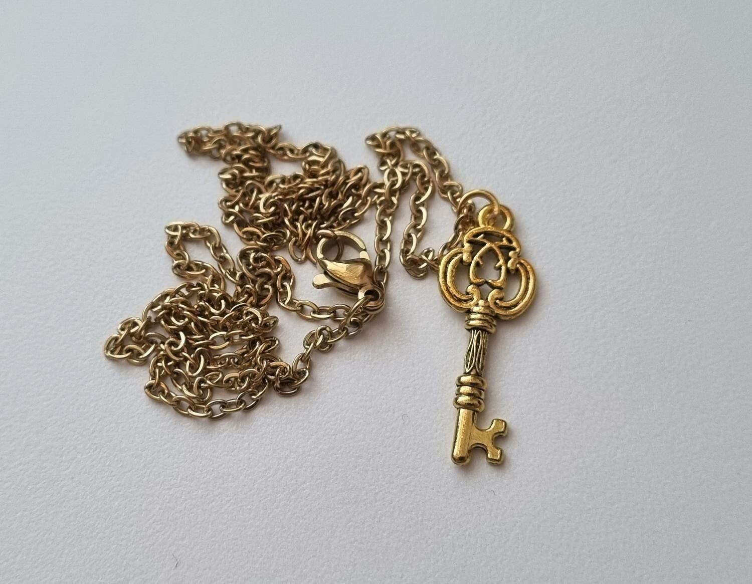 Halsband med en guldfärgad nyckel (50 cm lång kedja)
