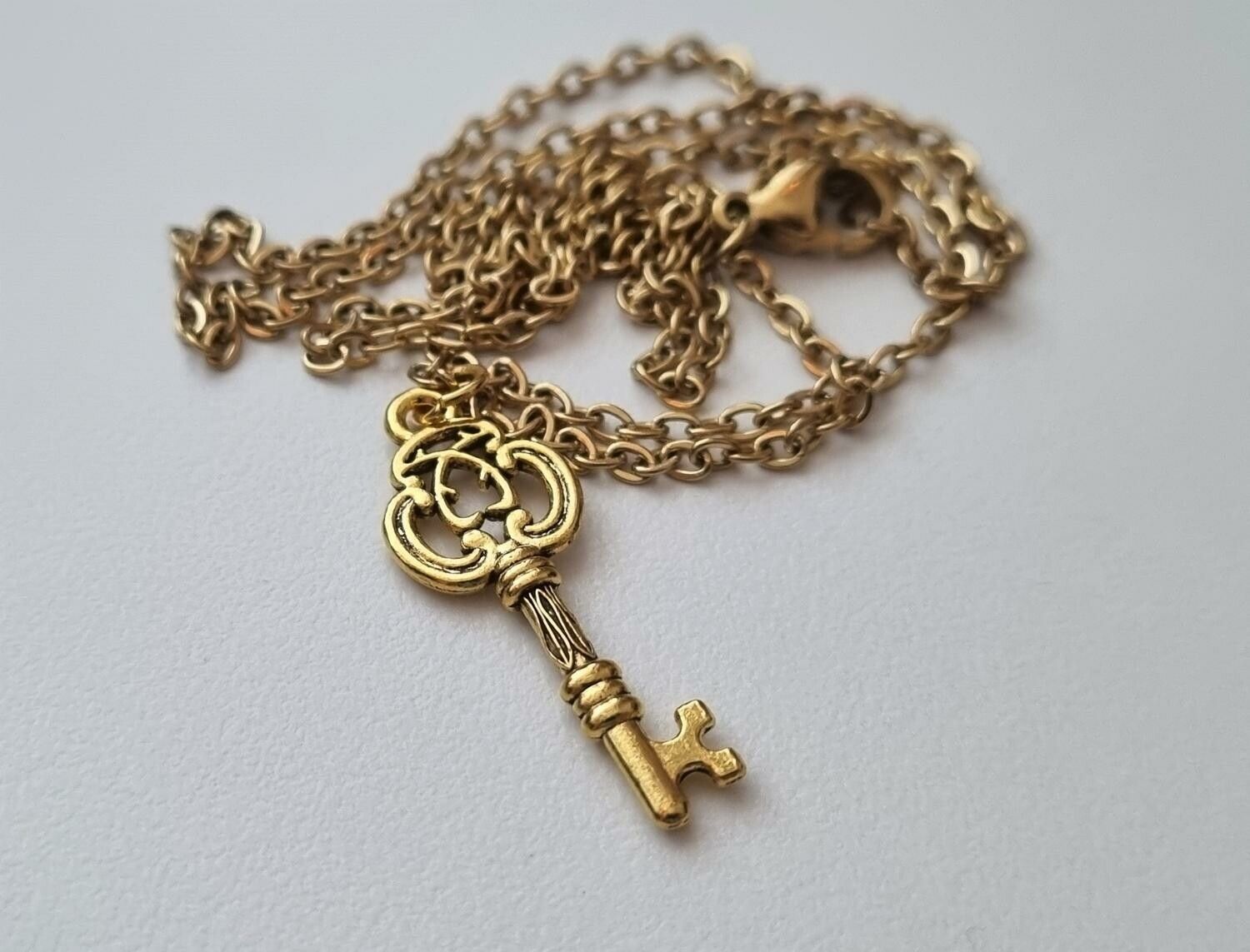 Halsband med en guldfärgad nyckel (50 cm lång kedja)