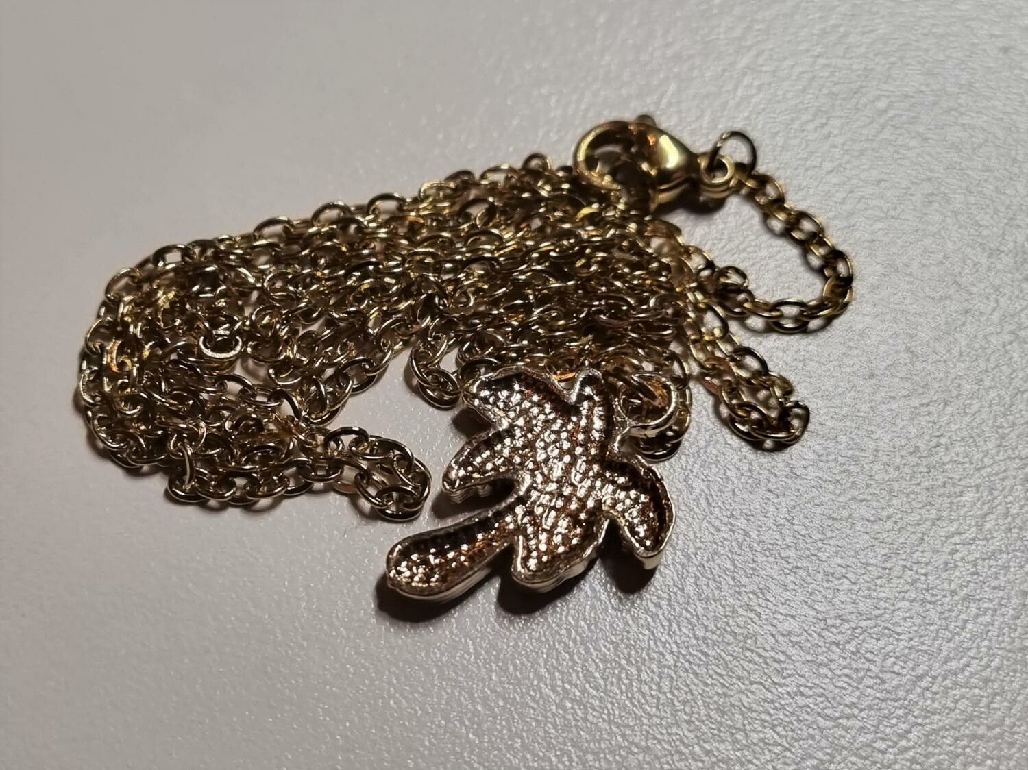 Guldfärgat halsband med ett palmträd, berlock / charm
