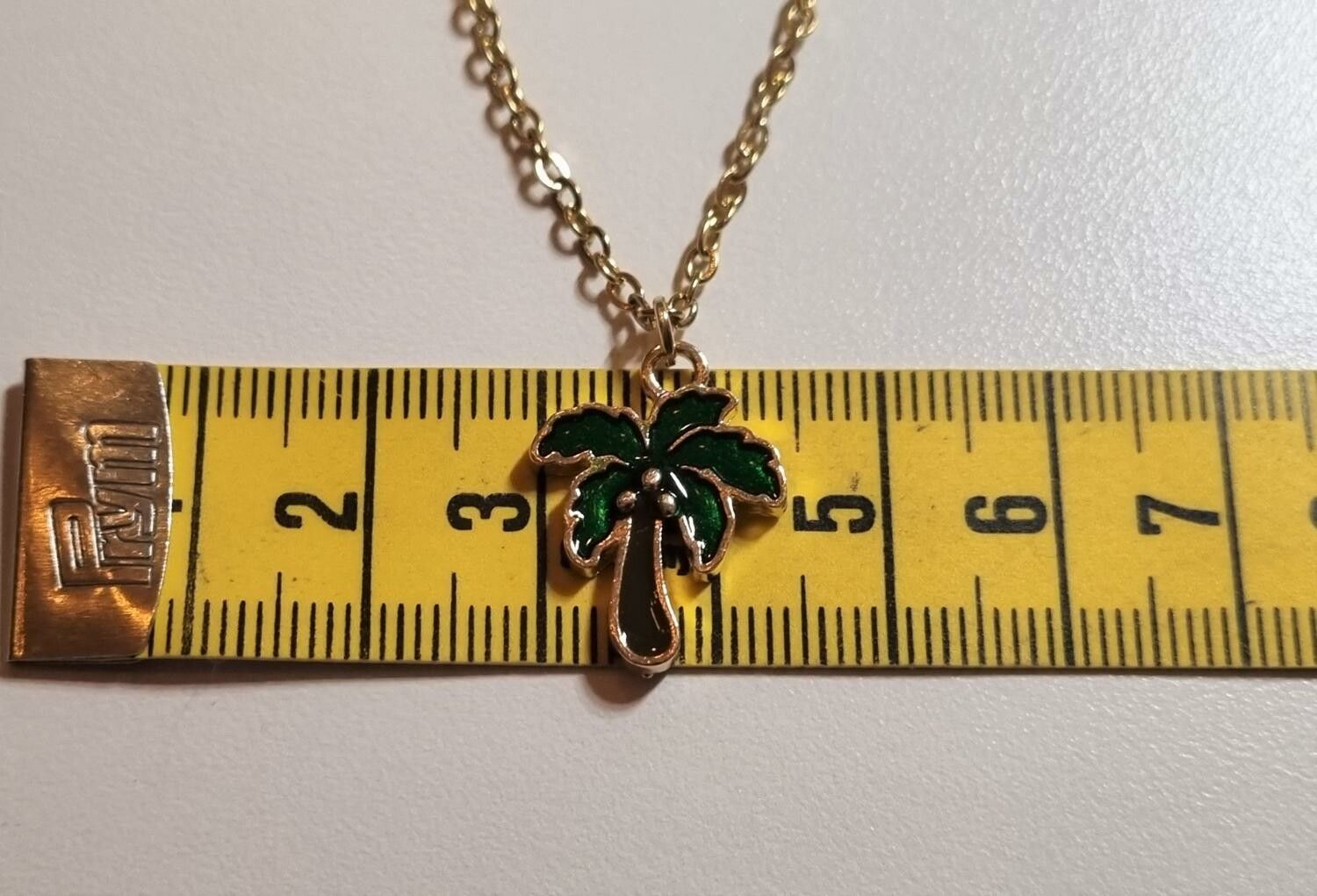 Guldfärgat halsband med ett palmträd, berlock / charm