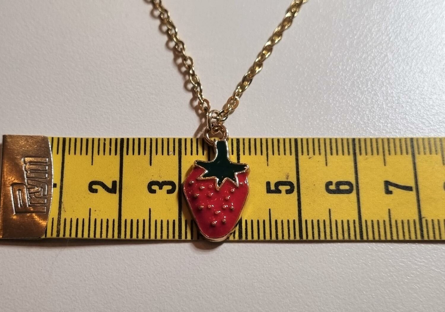 Guldfärgat halsband med en jordgubbe, berlock / charm