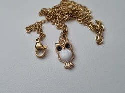 Guldfärgat halsband med en vit uggla