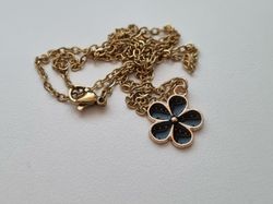 Guldfärgat halsband med en svart blomma / blomberlock