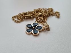 Guldfärgat halsband med en svart blomma / blomberlock