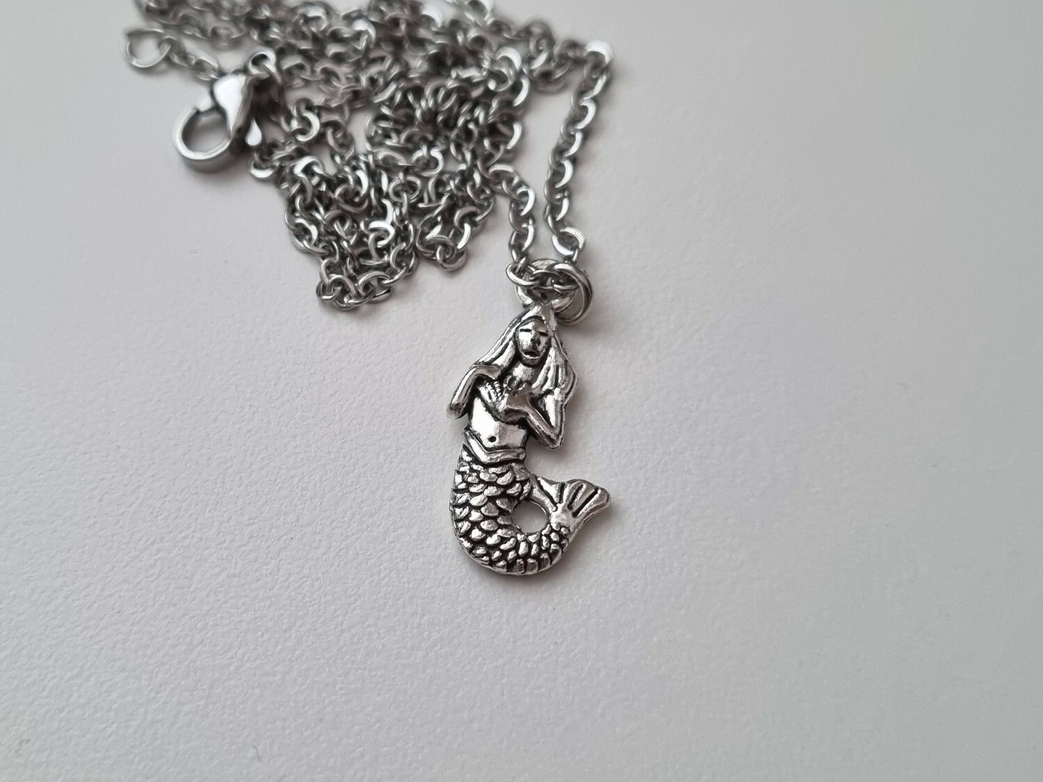 Silverfärgat halsband med en sjöjungfru