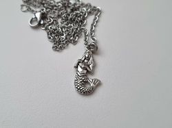 Silverfärgat halsband med en sjöjungfru