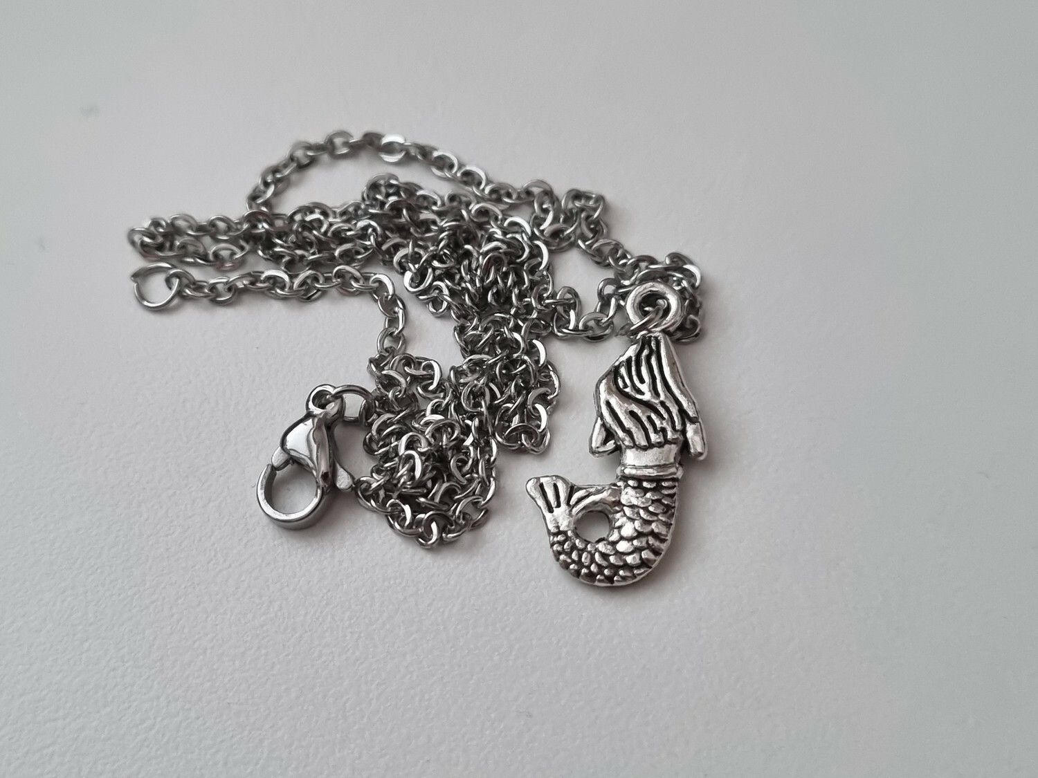 Silverfärgat halsband med en sjöjungfru