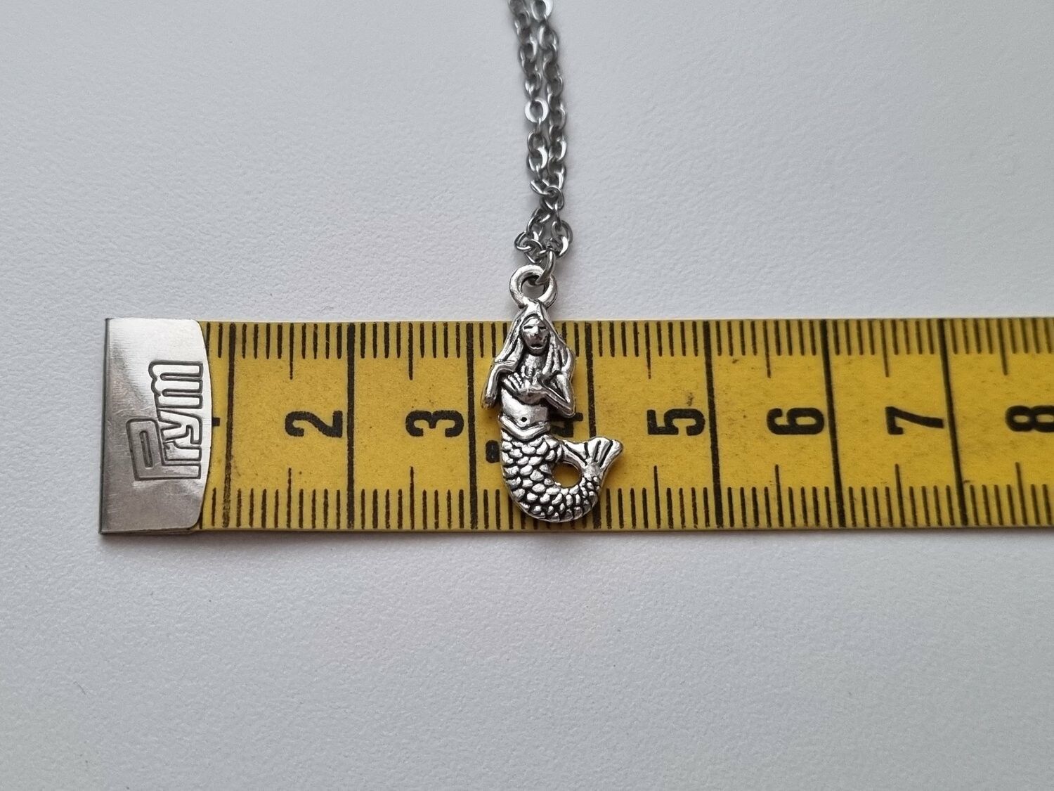 Silverfärgat halsband med en sjöjungfru