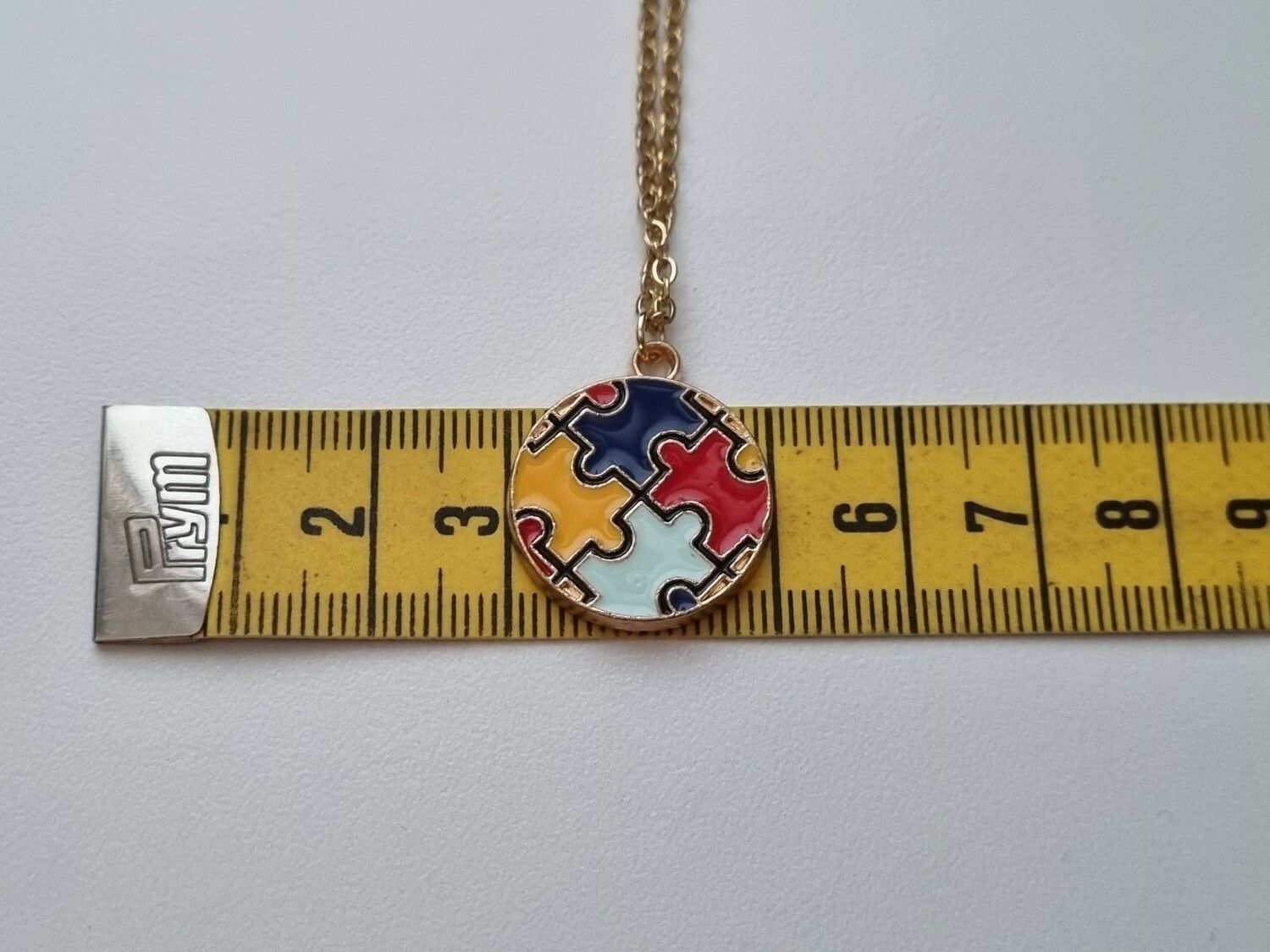 Guldfärgat halsband med en pusselbit / medvetenhet