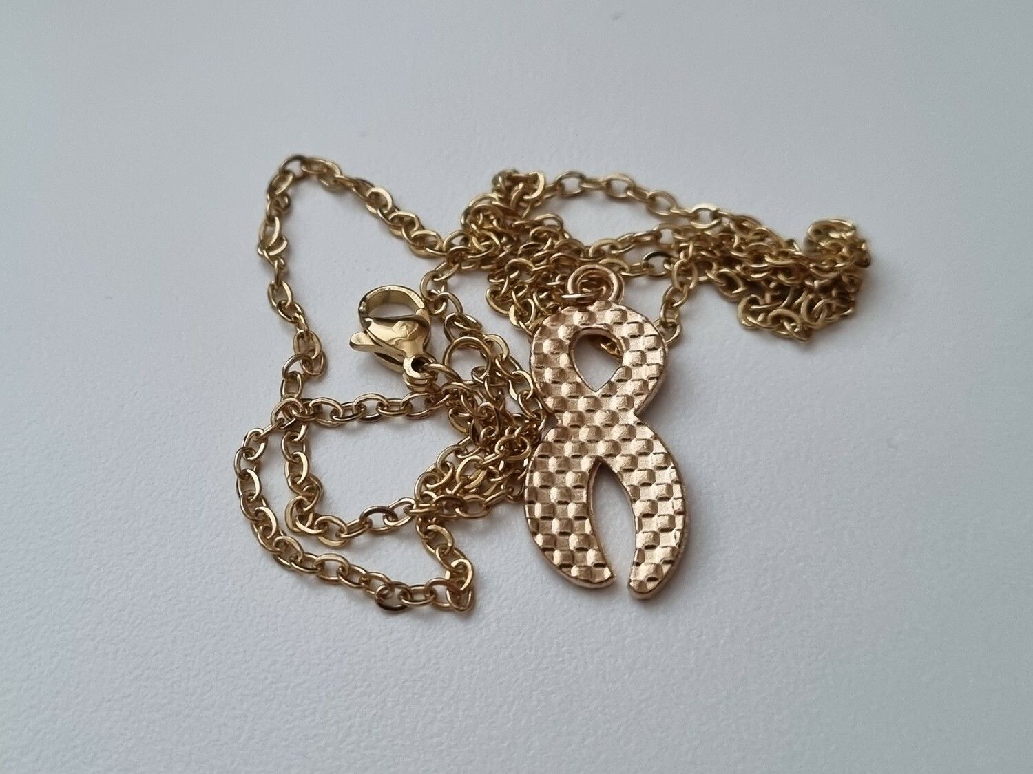 Guldfärgat halsband med en pusselbit / medvetenhet