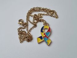 Guldfärgat halsband med en pusselbit / medvetenhet