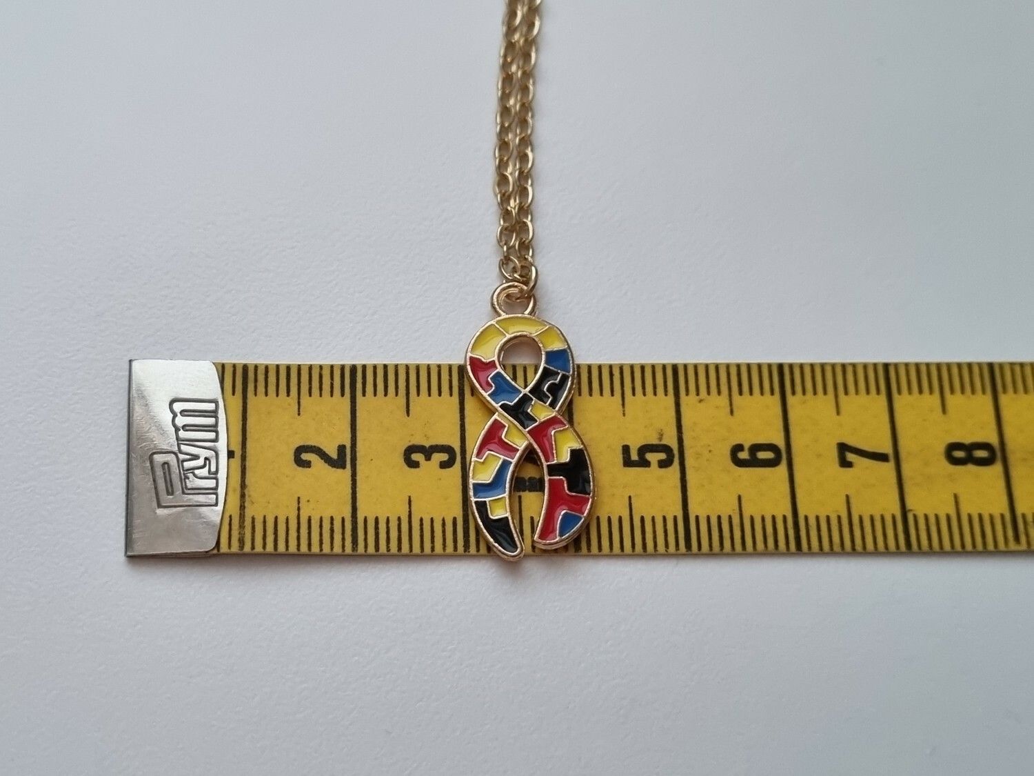 Guldfärgat halsband med en pusselbit / medvetenhet