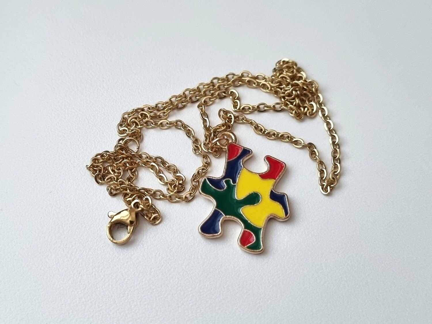 Guldfärgat halsband med en pusselbit / medvetenhet